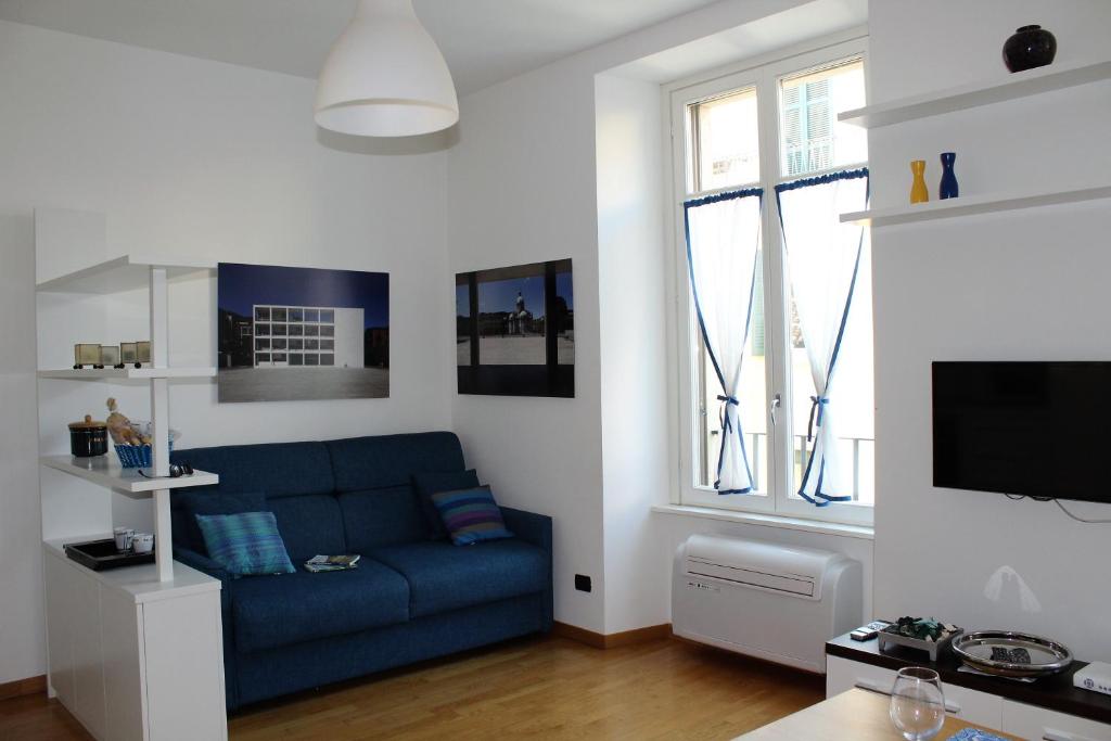 科莫Perfect apartment Como的客厅设有蓝色的沙发和2扇窗户。