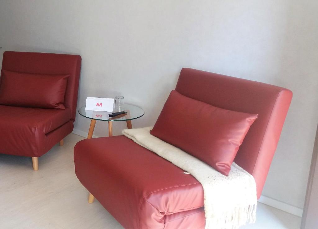 特罗Motel的客厅配有红色椅子和桌子
