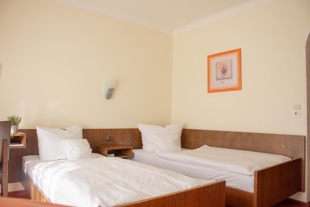 奥伊斯基兴罗特科普夫酒店餐厅的配有白色床单的客房内的两张床