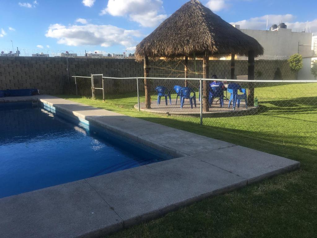 CuautlancingoCASA EN EL FRACCIONAMIENTO SAN FERNANDO 1的游泳池旁的凉亭,上面有蓝色的马匹