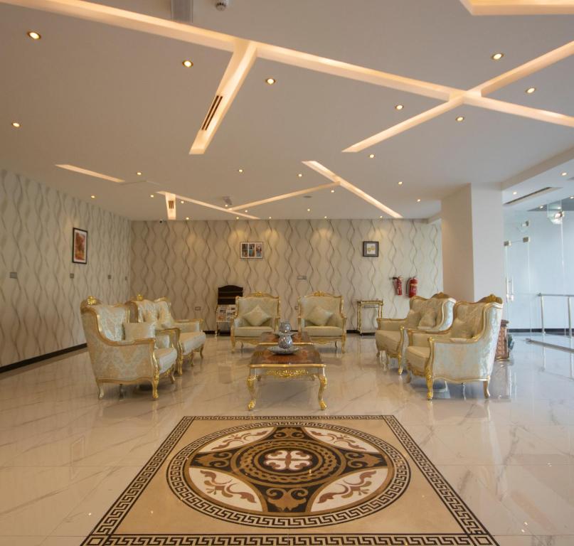 马斯喀特Home Station Hotel的大堂设有椅子、桌子和地毯。