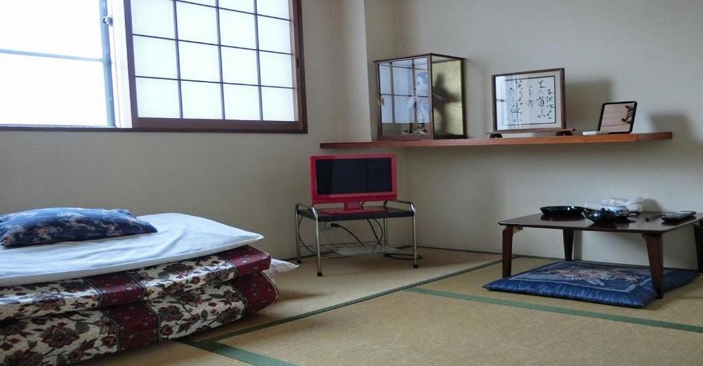 京都Ryokan Suzukisou-tatami room No bath and toilet- Vacation STAY 17862的一间卧室配有一张床和一张带笔记本电脑的桌子