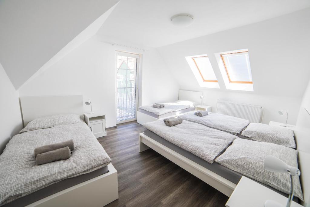 特热邦Penzion U parku Třeboň的卧室设有两张床,拥有白色的墙壁和木地板