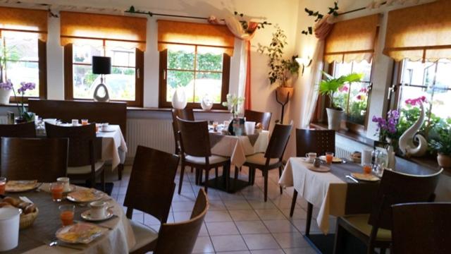 巴贝Hotel Birkenhof Garni的用餐室设有桌椅和窗户。