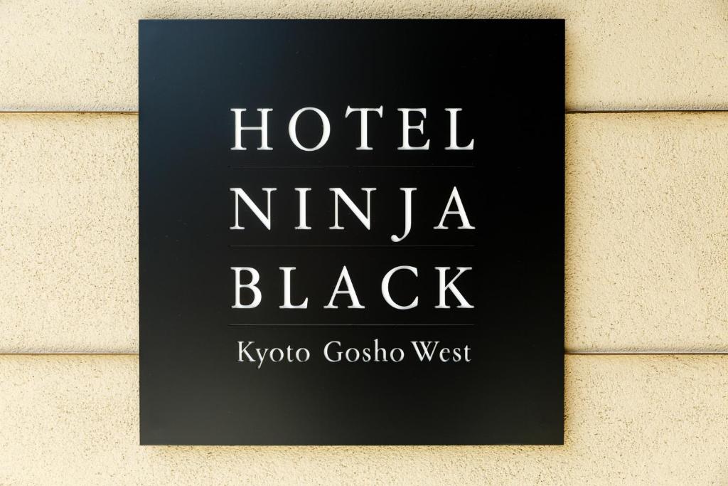 京都Hotel Ninja Black的墙上黑的旅馆标志