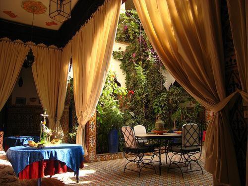 塔鲁丹特玛丽亚姆塔鲁丹特里亚德酒店的庭院配有窗帘和桌椅
