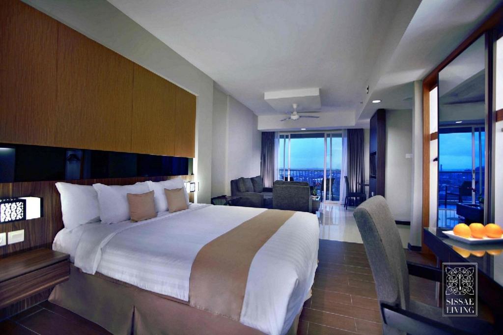 巴厘巴板The Malibu Suites Balikpapan by Sissae Living的一间带大床的卧室和一间客厅