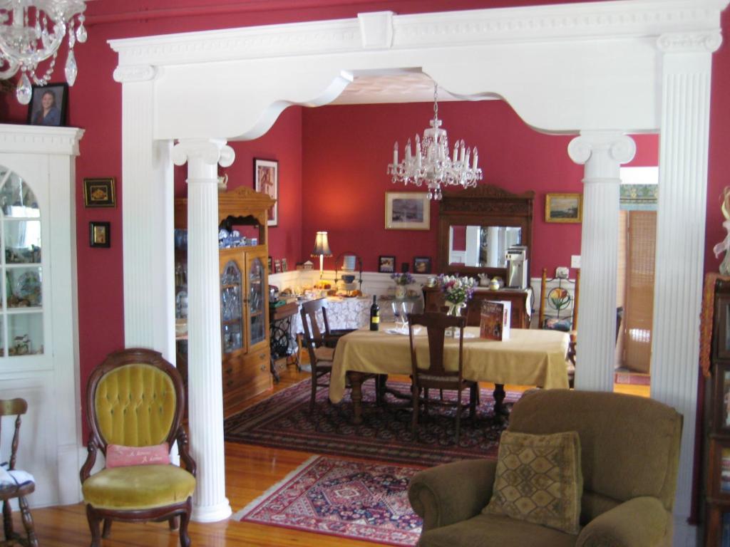 纽波特希尔历史住宿加早餐旅馆的一间拥有红色墙壁和桌椅的用餐室