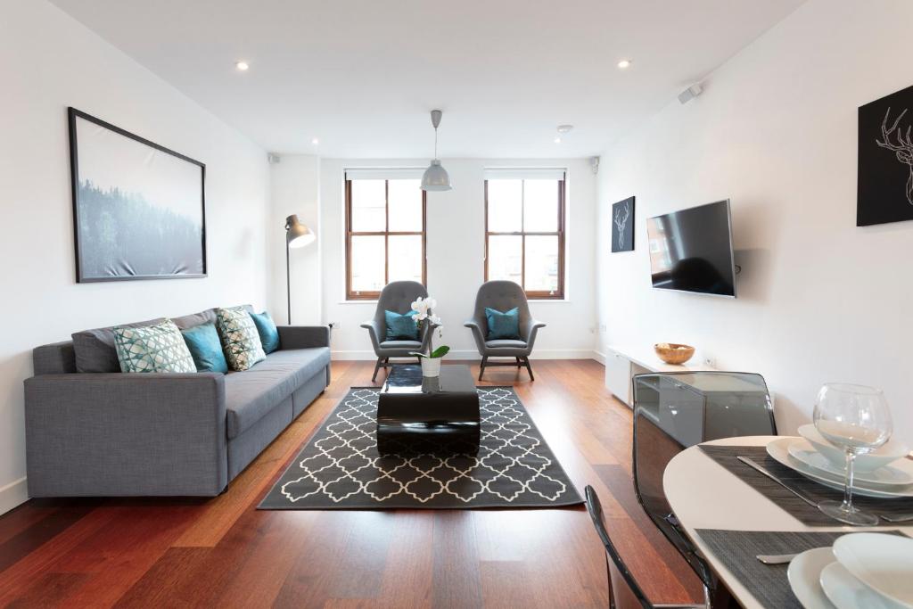 温莎Hampden Apartments - The Charles的客厅配有沙发和桌子