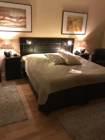 恩厄尔霍尔姆里尔顿酒店的一间卧室配有一张带两盏灯和一把椅子的床。