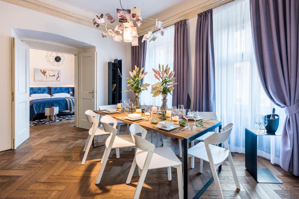 布拉格城堡旁MOOo公寓式酒店的一间配备有蓝桌和白色椅子的用餐室
