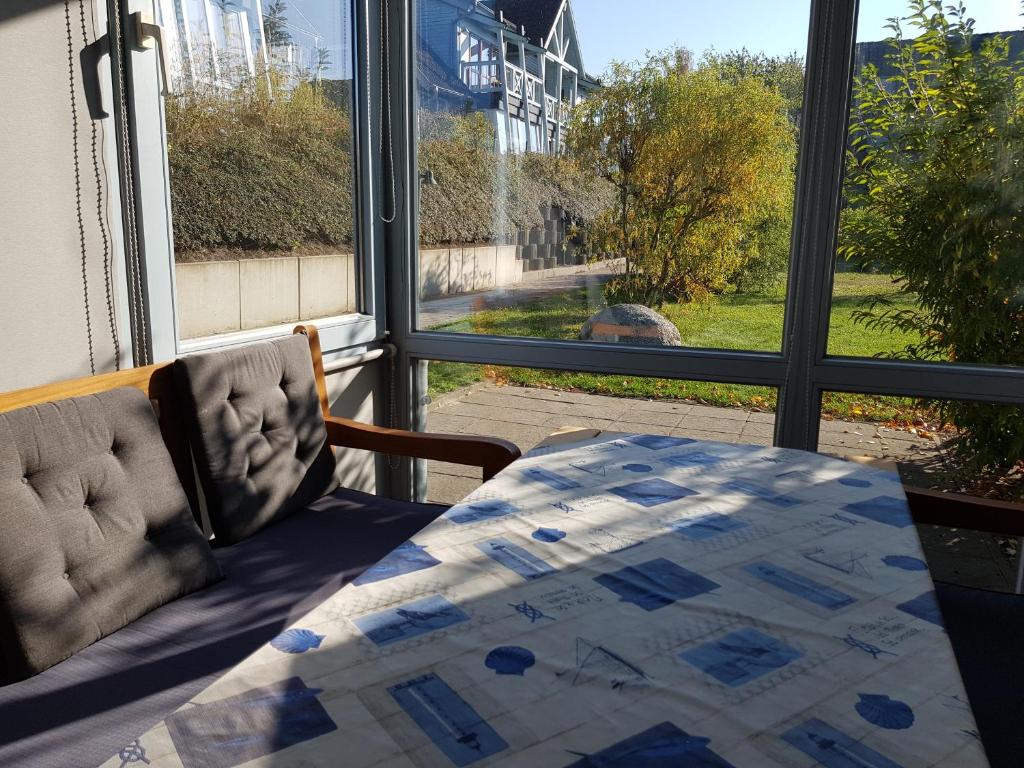塞多夫Ferienwohnung 4 im Haus am See mit Wintergarten und Terrasse的一间卧室配有一张床、一张桌子和一个窗户。