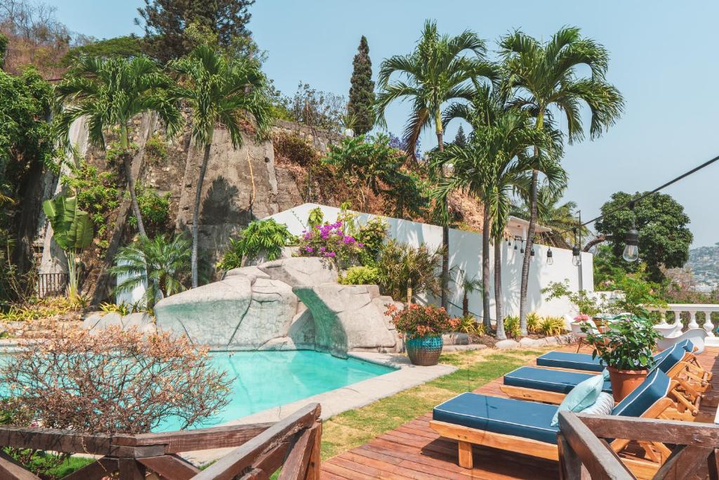 瓜亚基尔Iguanazu Bed & Breakfast的一个带躺椅和水滑梯的游泳池