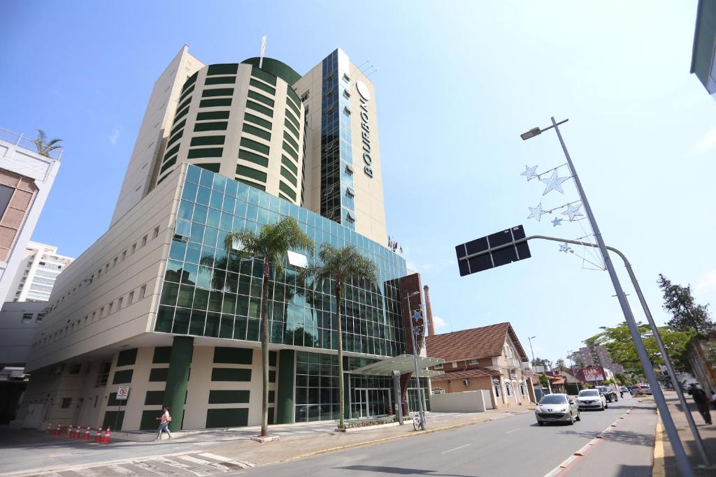 约恩维利Bourbon Joinville Convention Hotel的城市街道上一座高大的建筑,有交通灯