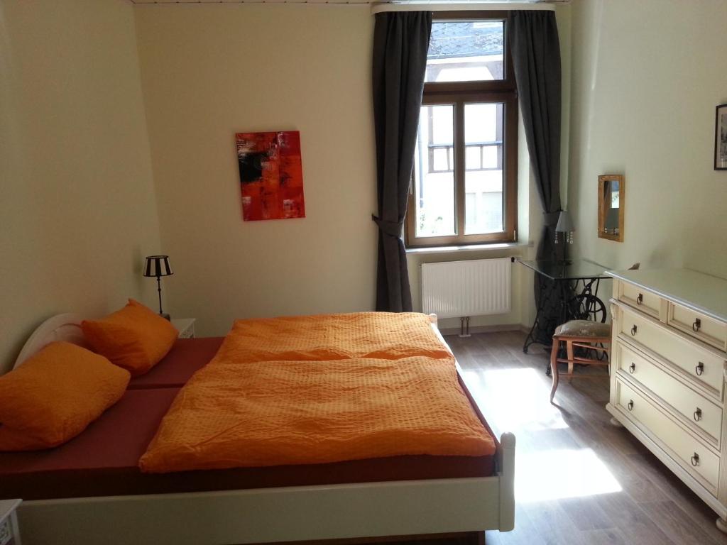 贝尔恩卡斯特尔-库斯Bernkastler Graben的一间卧室配有一张带橙色毯子的床