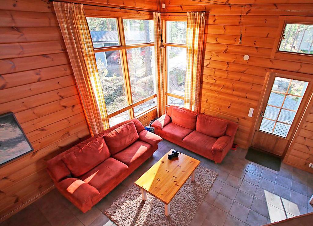 Oravi奥拉维度假屋的客厅配有两张红色的沙发和一张桌子