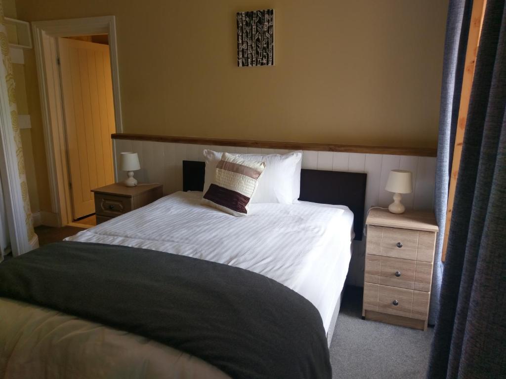 普里茅斯加勒里旅馆 的一间卧室配有带白色床单和枕头的床。