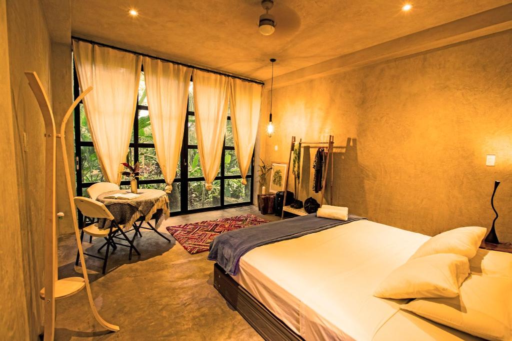 马尔多纳多港Kapievi Ecovillage的一间卧室配有一张床、一张桌子和一个窗户。