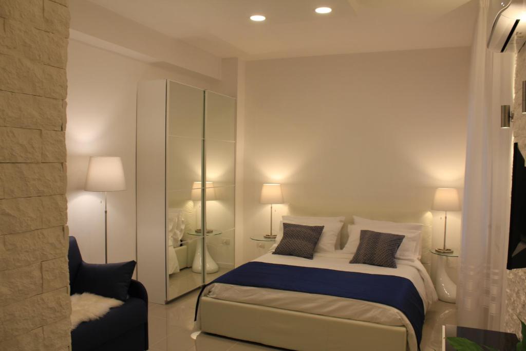 那不勒斯Casa Teresa Bed & Breakfast的一间卧室配有一张带两盏灯和一把椅子的床。