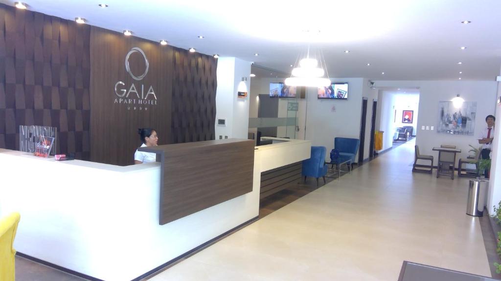 塔里哈Gaia Apart Hotel的坐在大堂柜台上的人