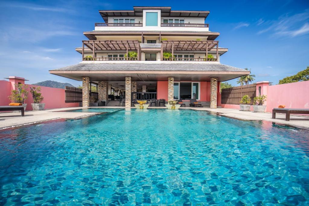 拉威海滩Ratana Hotel Chalong的大楼前带游泳池的房子