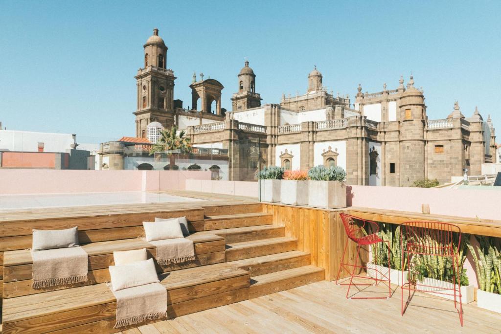 大加那利岛拉斯帕尔马斯VEINTIUNO Emblematic Hotels - Adults Only的从带椅子的建筑屋顶上欣赏美景