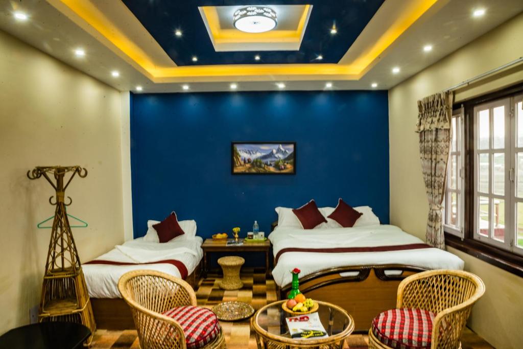 KirtipurHomestay Nepal的一间卧室设有两张床和蓝色的墙壁
