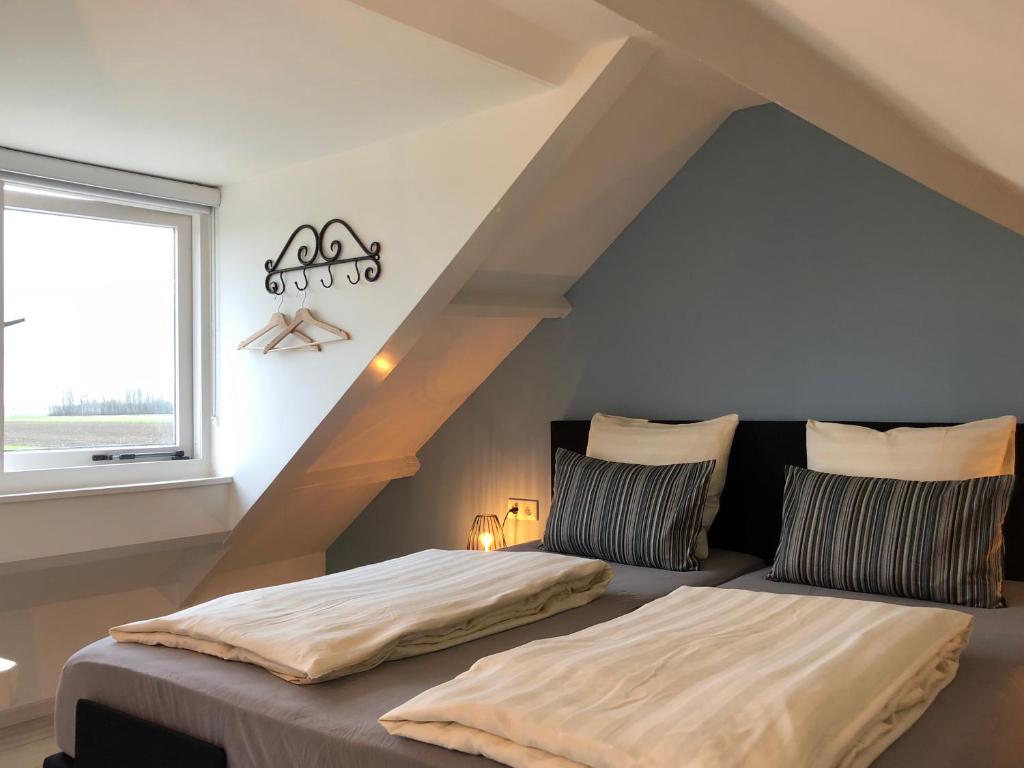 坎珀兰Fila Stroo的阁楼卧室设有两张床和窗户。