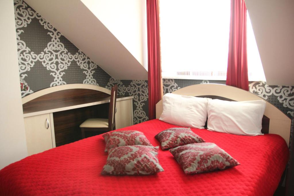 拉多姆Prymus的一间卧室配有红色的床和两个枕头
