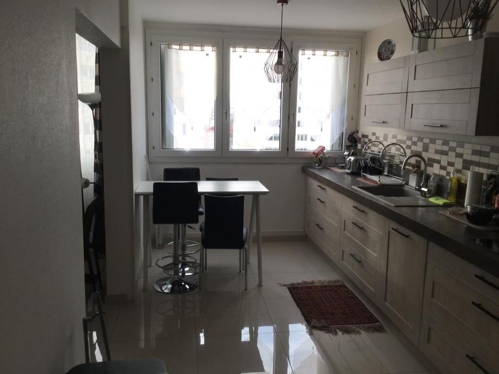 维勒班Appartement Laurent Bonnevay的厨房配有桌椅和窗户。