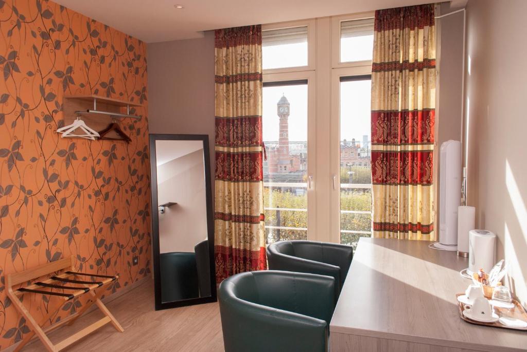 根特卡斯特尔酒店的客房设有桌椅和窗户。