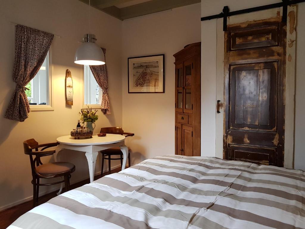 欣德洛彭Atelier B&B 'Sinnestriel'的一间卧室配有一张床和一张桌子及椅子
