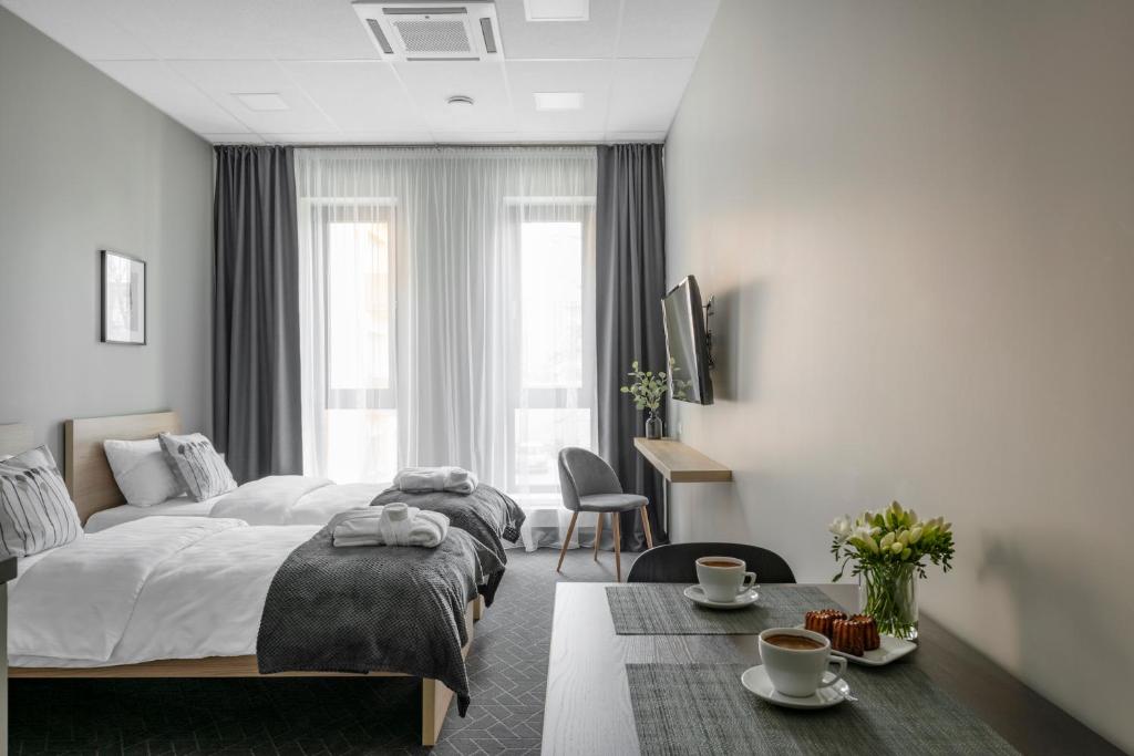 陶拉格Senamiesčio apartamentai的一间卧室配有一张床和一张带咖啡杯的桌子