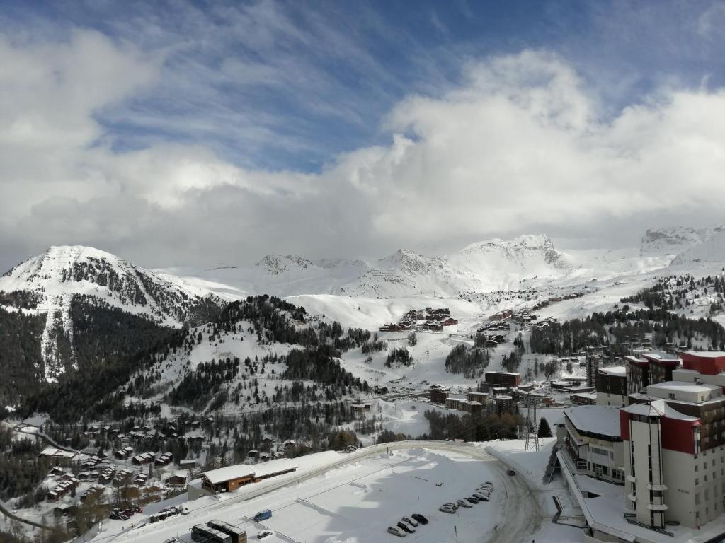 艾姆拉普拉涅Plagne AIME 2000 Ski Apartments的享有白雪 ⁇ 的山脉和城市的景致
