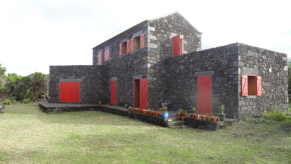圣罗克杜皮库Retiro dos Bons Sinais的黑色石屋,设有红色门窗