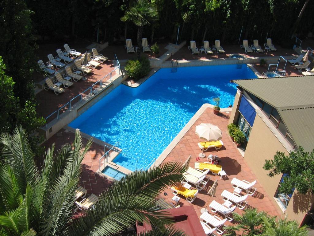 罗马阿尔德罗万迪城市套房酒店的享有带椅子和遮阳伞的游泳池的上方景致