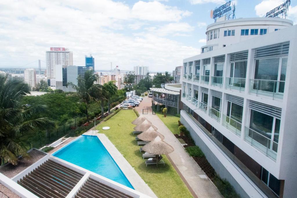 马普托Montebelo Girassol Maputo Hotel的从大楼的阳台上可欣赏到游泳池的景色