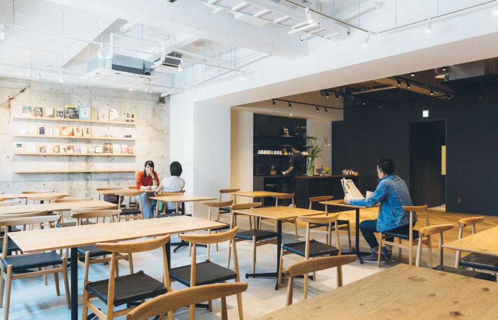 熊本雷斯特斯住宿酒店的一间设有桌子的餐厅,有坐在桌子上的人