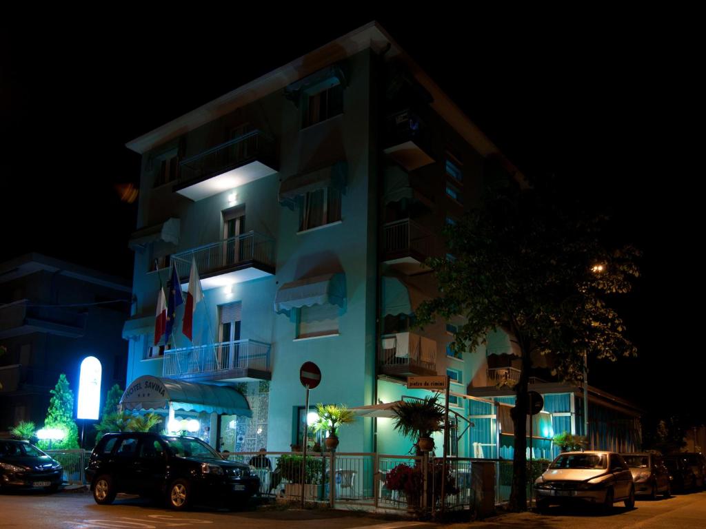 里米尼萨维娜酒店的一座建筑,晚上停在前面