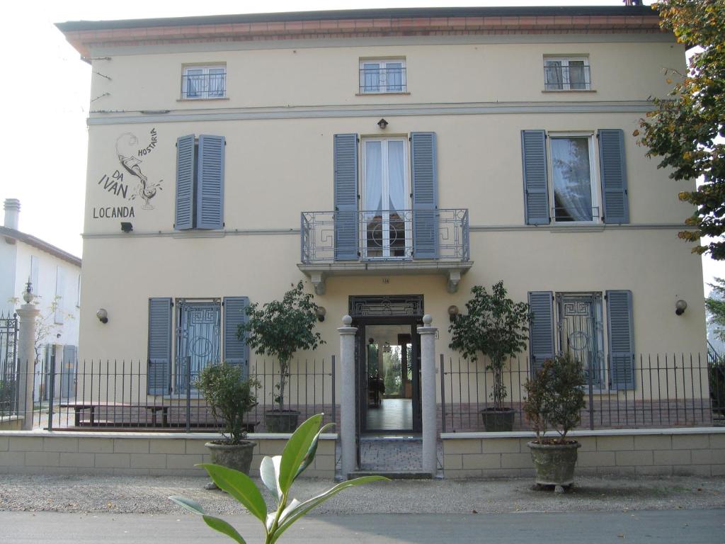 RoccabiancaHostaria Da Ivan的一座建筑,设有蓝色百叶窗和门