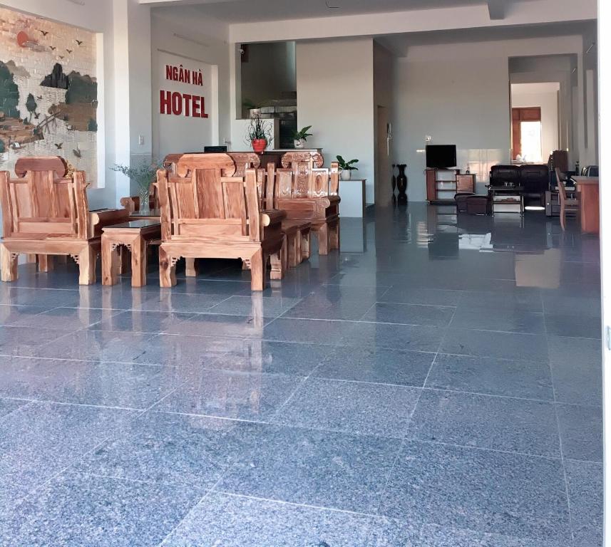 绥和市khách sạn Ngân Hà的一间设有木椅的房间和一间酒店的房间