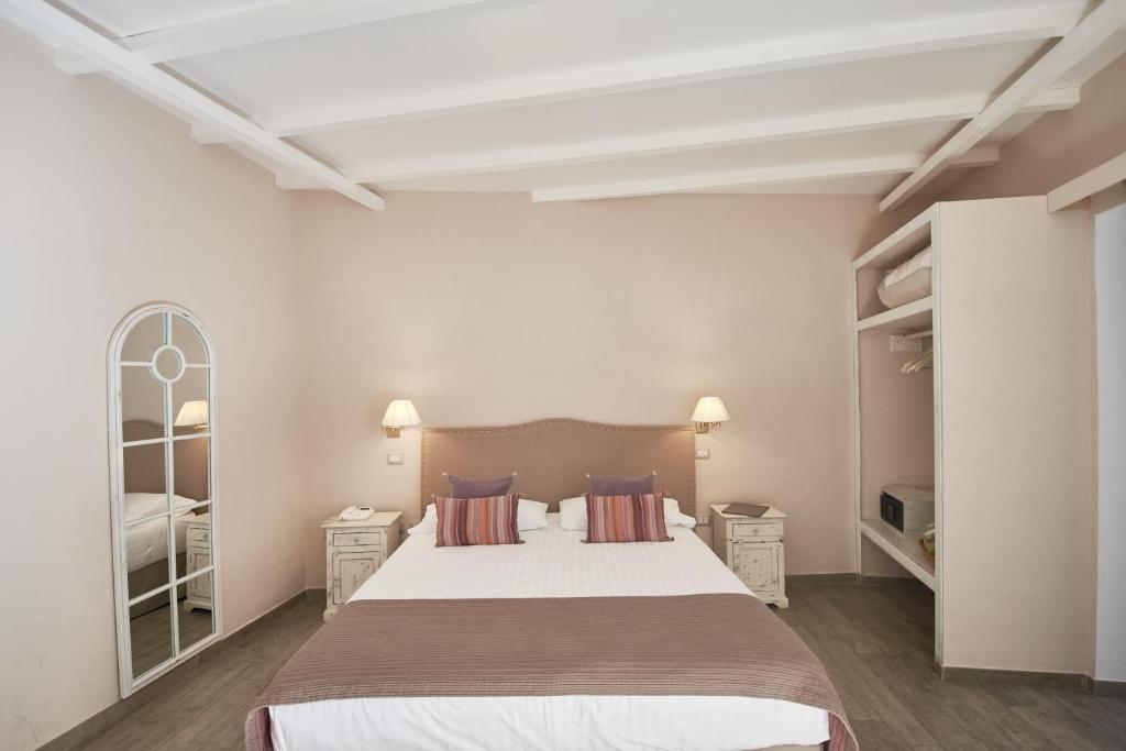 卡塞塔卡瑟迷人酒店的一间卧室设有一张大床和两个床头柜