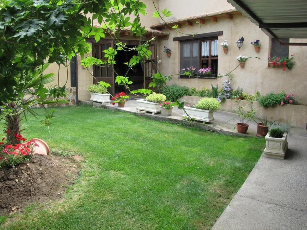 Villarente奥博格圣佩拉约酒店的种有盆栽植物的院子和房子