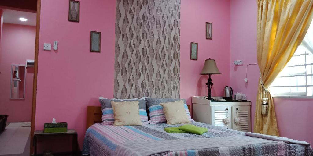 古晋Jazepuri - Jaze 3的卧室设有粉红色的墙壁和一张大床