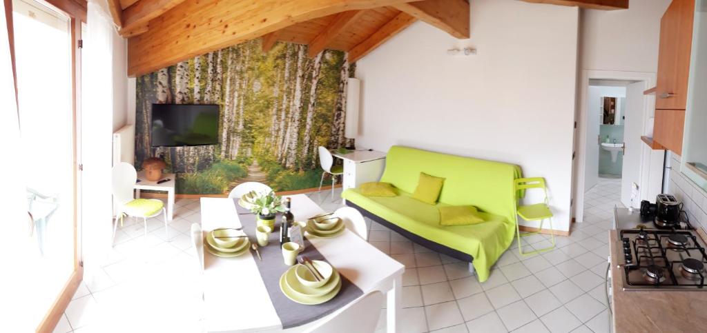 加尔达湖滨Appartamento Betulla的客厅配有绿色沙发和电视
