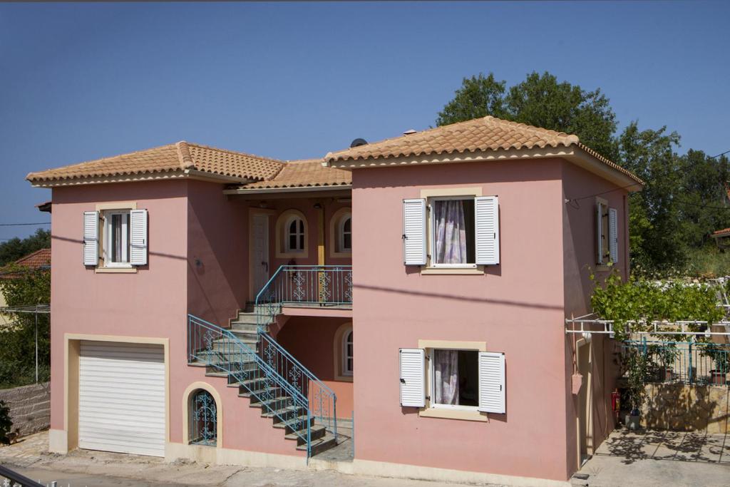 斯沃伦塔Kantouni Apartments的粉红色的房子前面设有楼梯