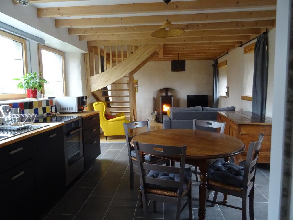 BégardGites du Hérisson的厨房以及带桌椅的起居室。