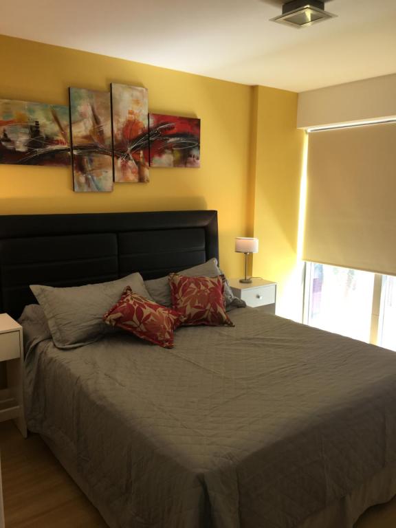 门多萨Boulogne Design Suites的一间卧室配有一张带两个枕头的床
