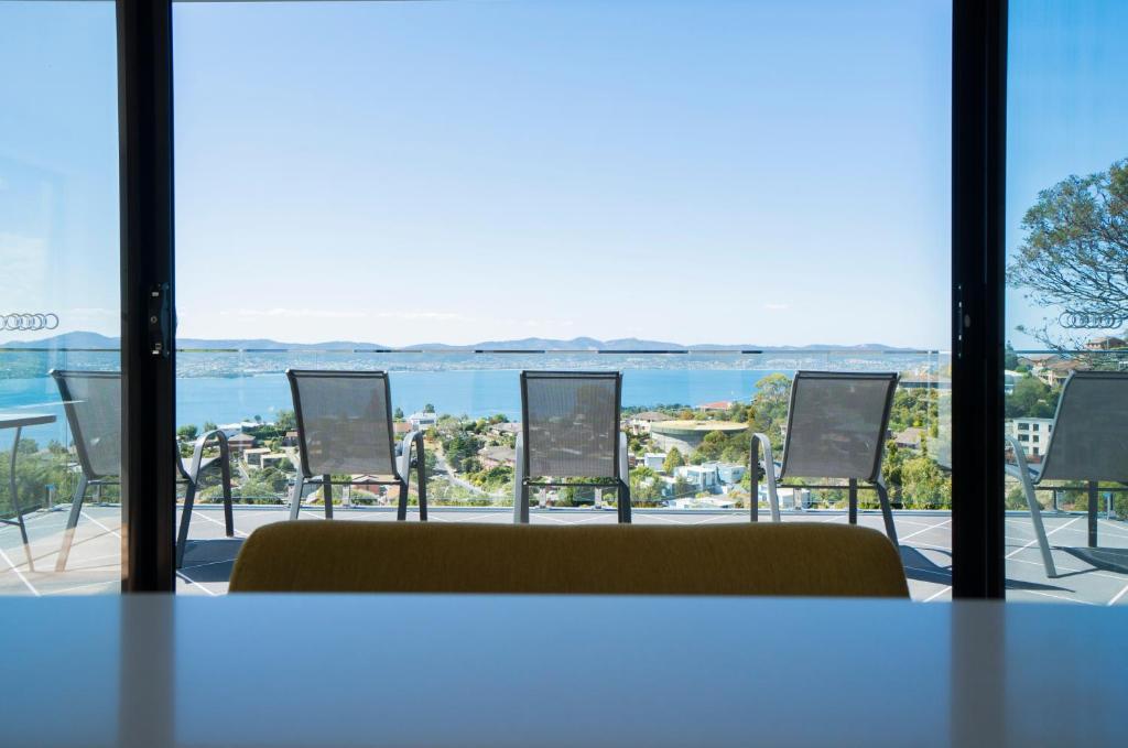 霍巴特Amazing Sea Views Luxury Guest House的配有椅子并享有水景的客房