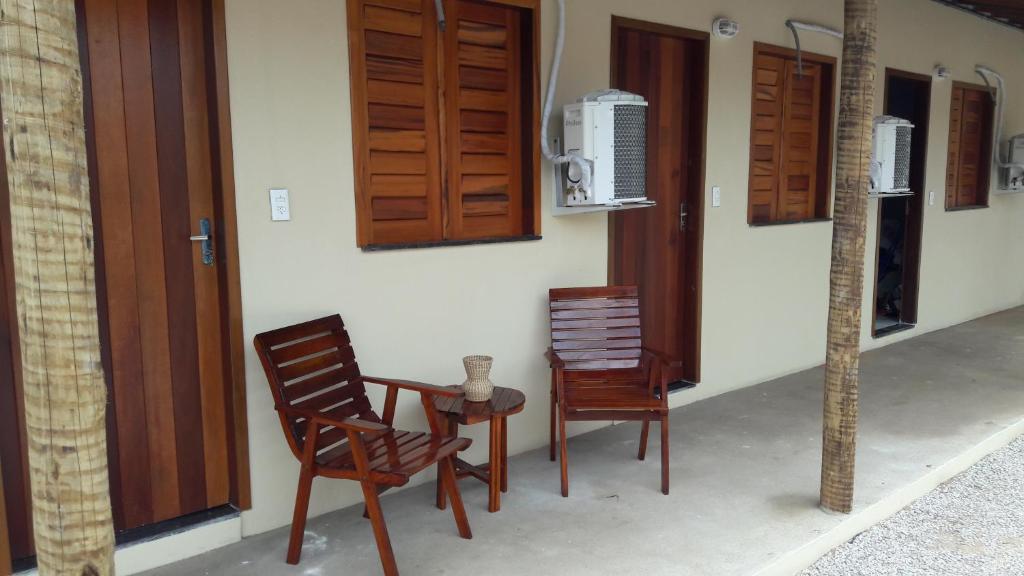 福廷Villa Portal dos Ventos的房子前面的两把椅子和一张桌子